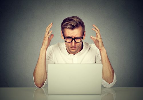Wrong email Stressed man working on computer sends wrong email. Negative human emotion face expression.